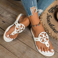 White flat sandals with cutout logo straps and two buckle details