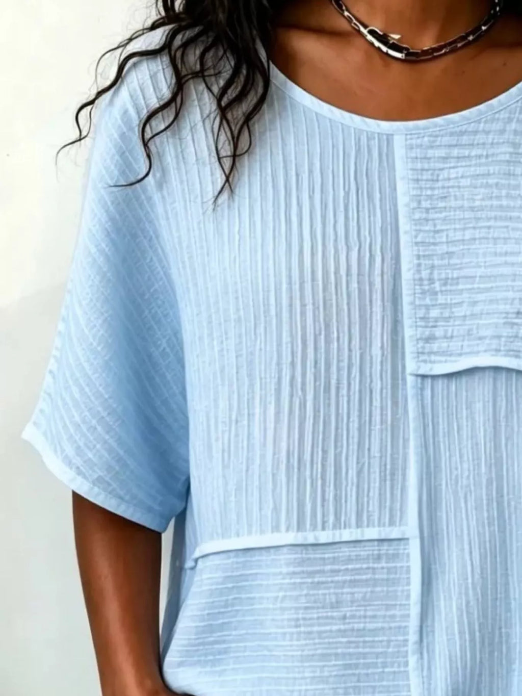 Textured light blue round-neck half-sleeve blouse with vertical rib pattern and pocket flap