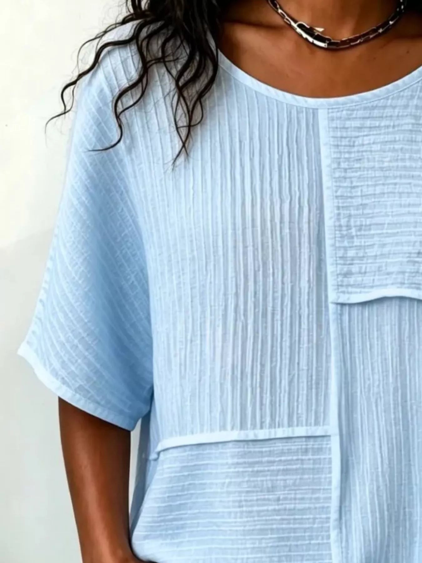 Textured light blue round-neck half-sleeve blouse with vertical rib pattern and pocket flap