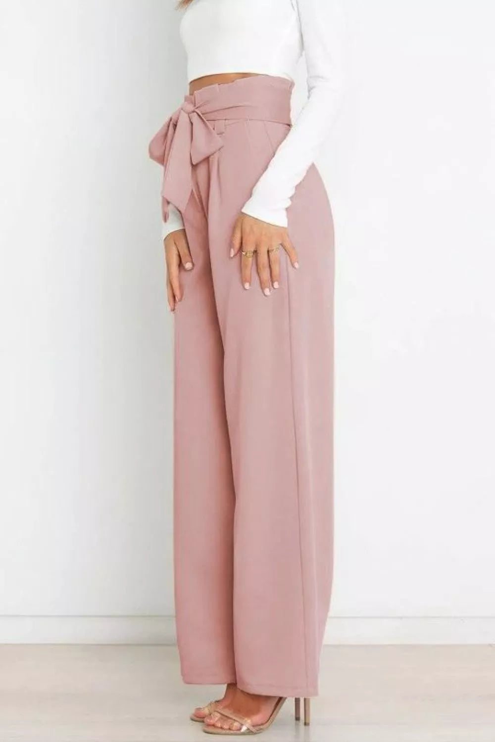 Blush pink high-waist tie-front wide-leg pants, side view with bow waist detail