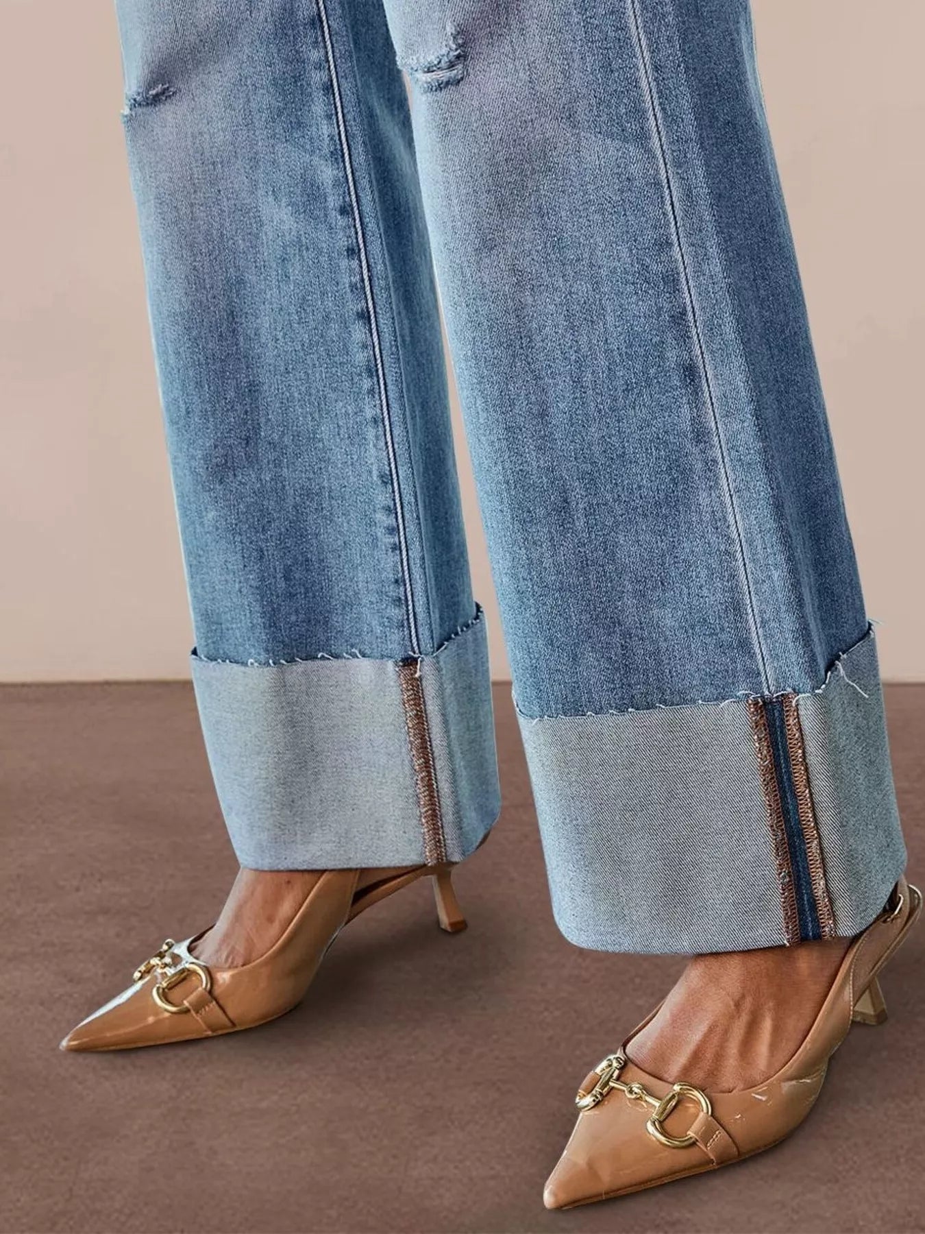 Light blue flare jeans close-up: frayed hem and worn wash at the cuff