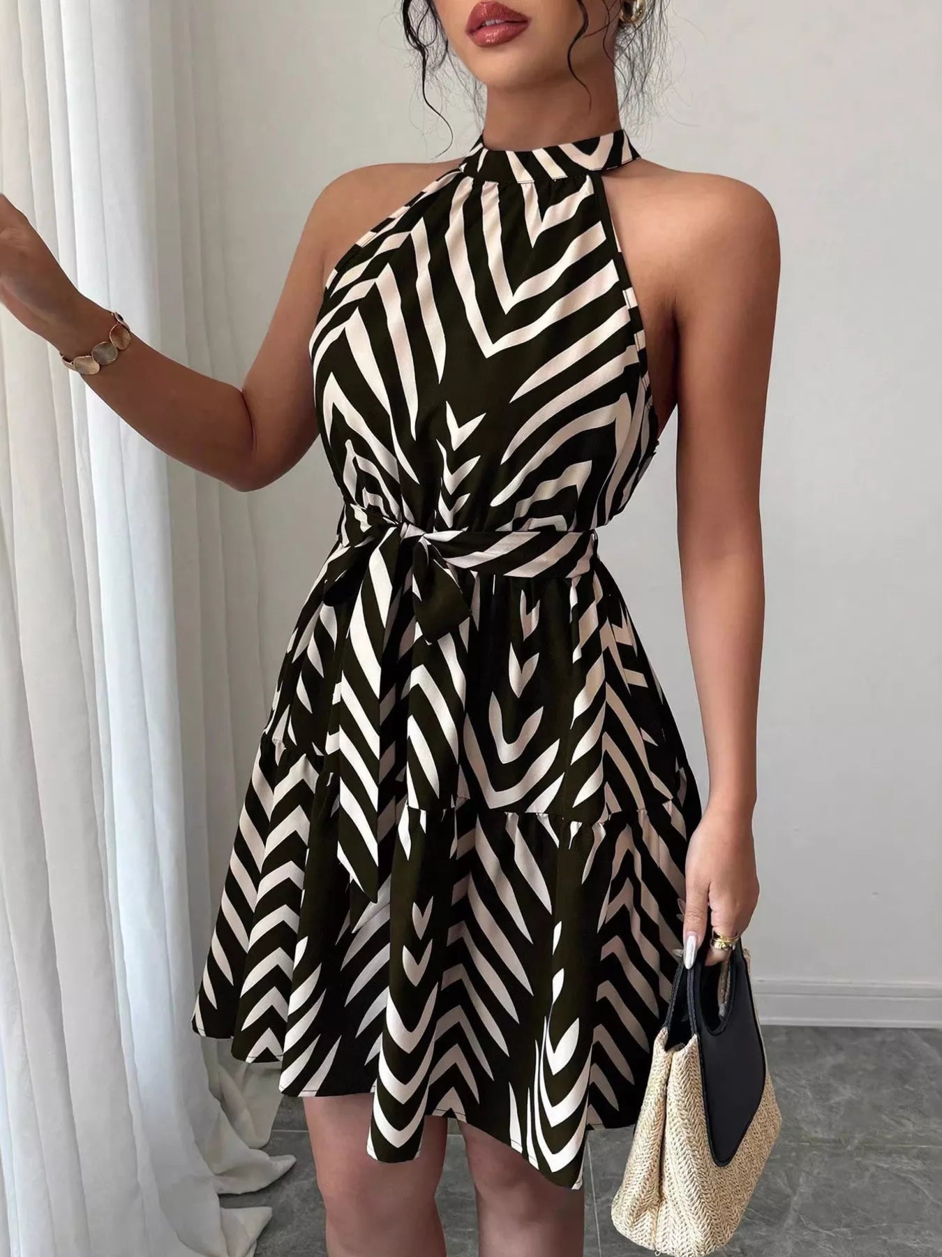 Black zebra-print halter dress with tie waist and ruffle hem, flared skirt