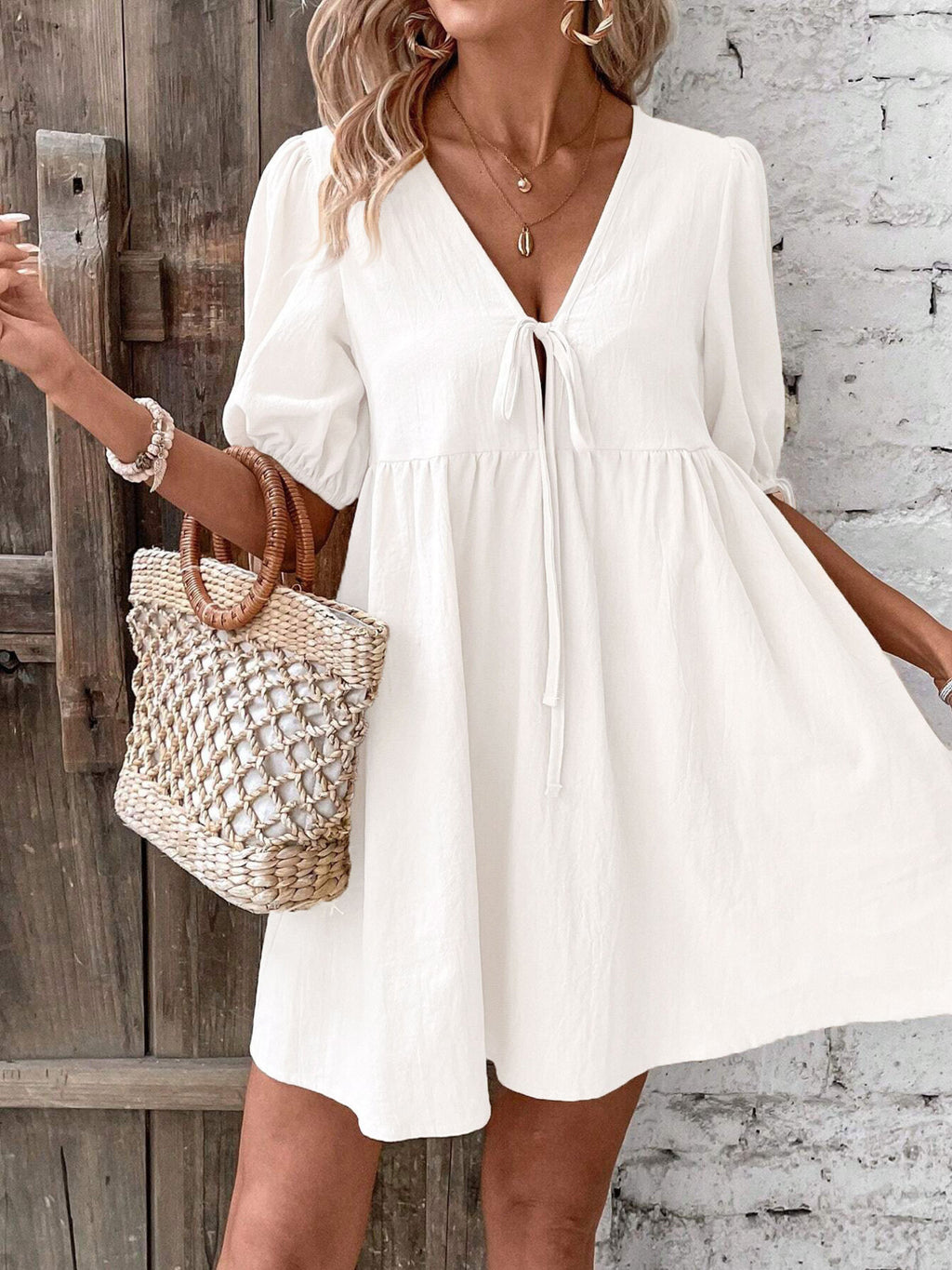 White tie-front mini dress with puff sleeves, gathered waist and V-neck