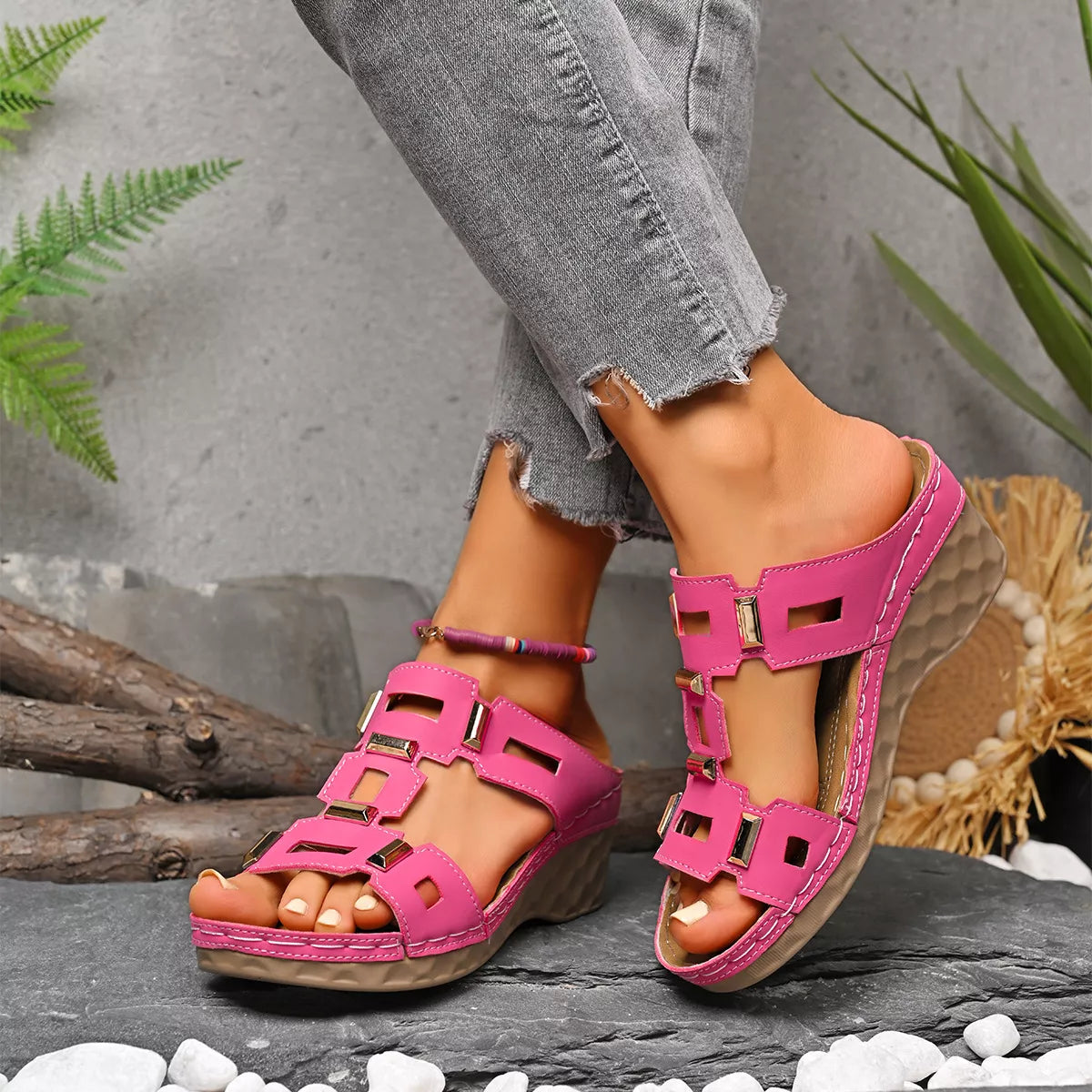 Pink open-toe wedge sandal with cutout straps and buckle closures, textured sole.