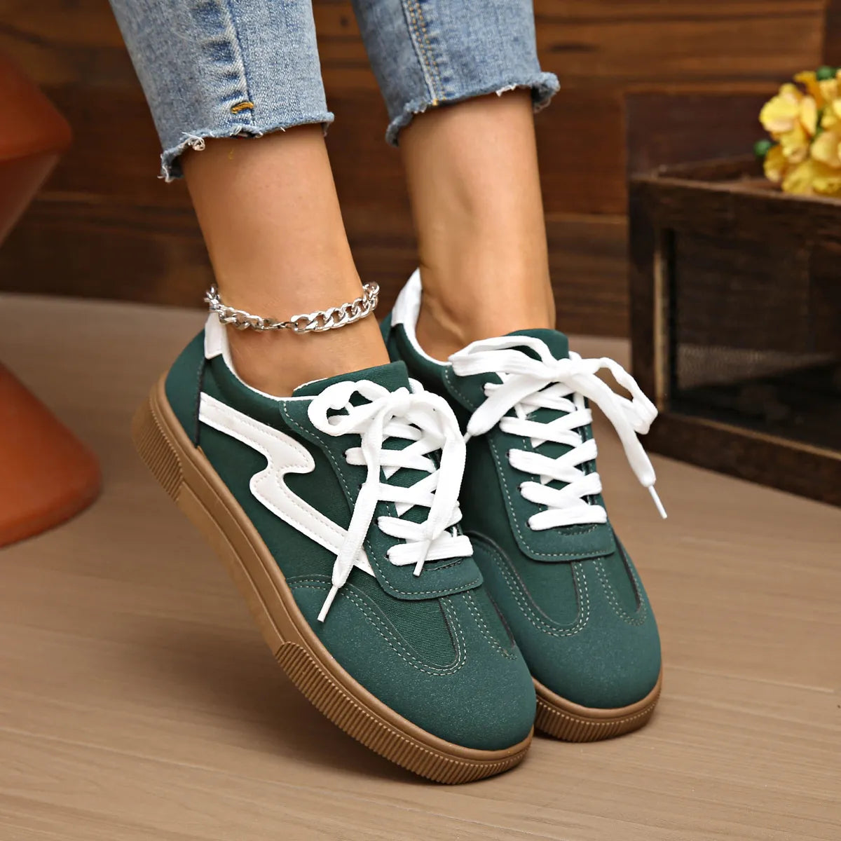 Dark green lace-up sneakers with white laces and contrast white panels