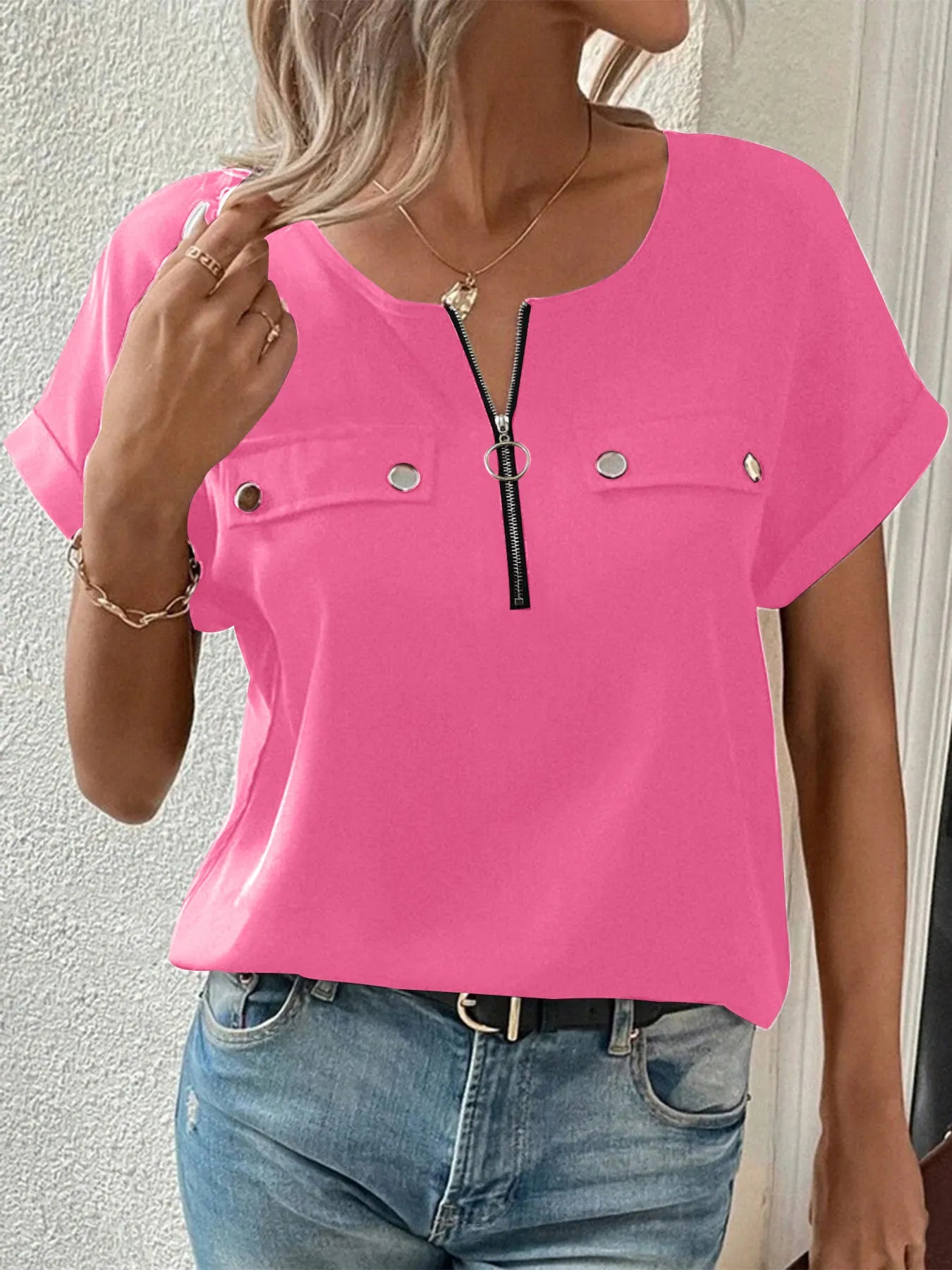 Pink short-sleeve blouse with front zipper and snap pockets at the chest