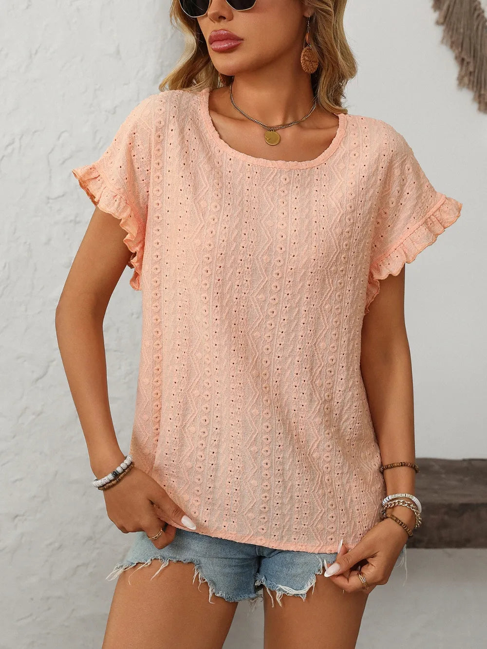 Light pink eyelet short-sleeve top with round neck and flutter sleeves