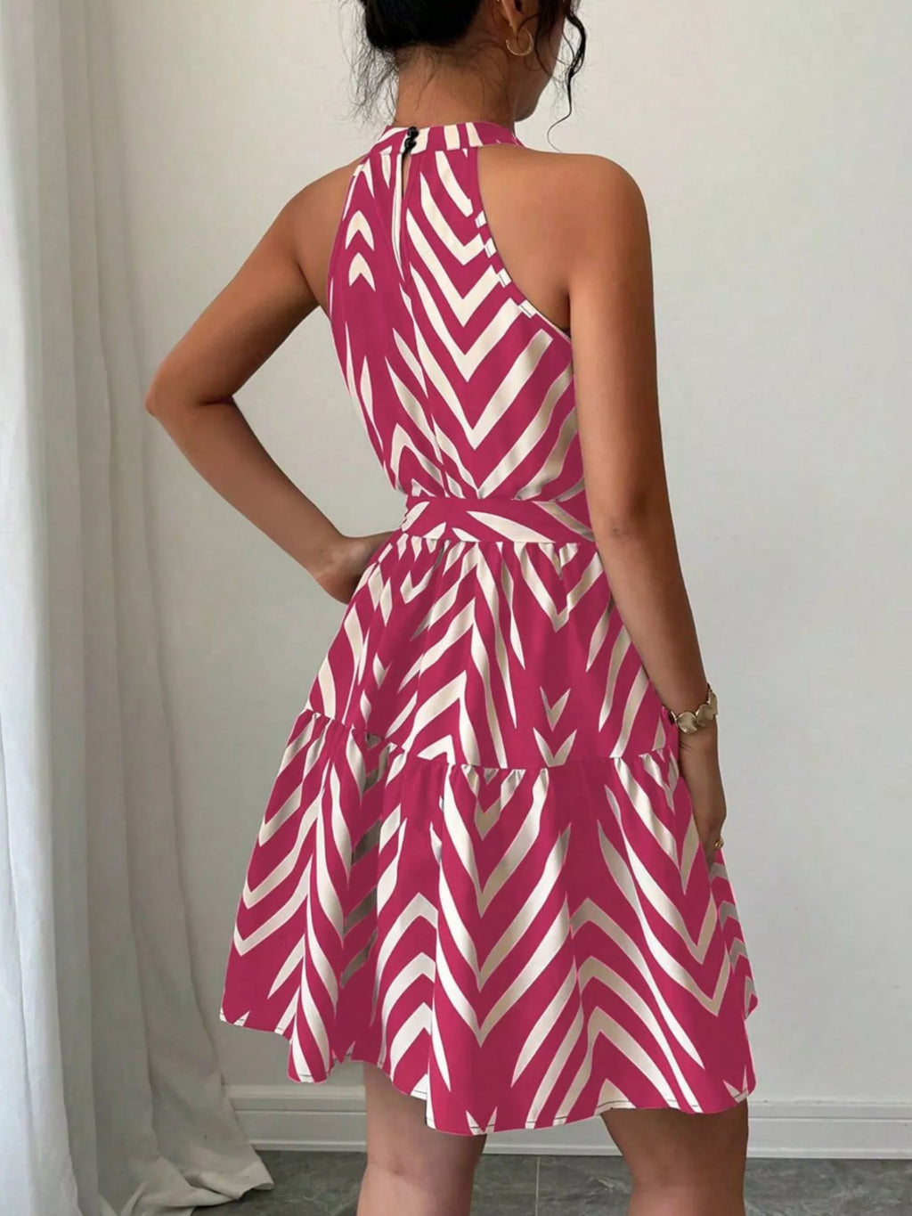 Back view: rose red zebra print halter dress with tie waist and layered ruffle hem