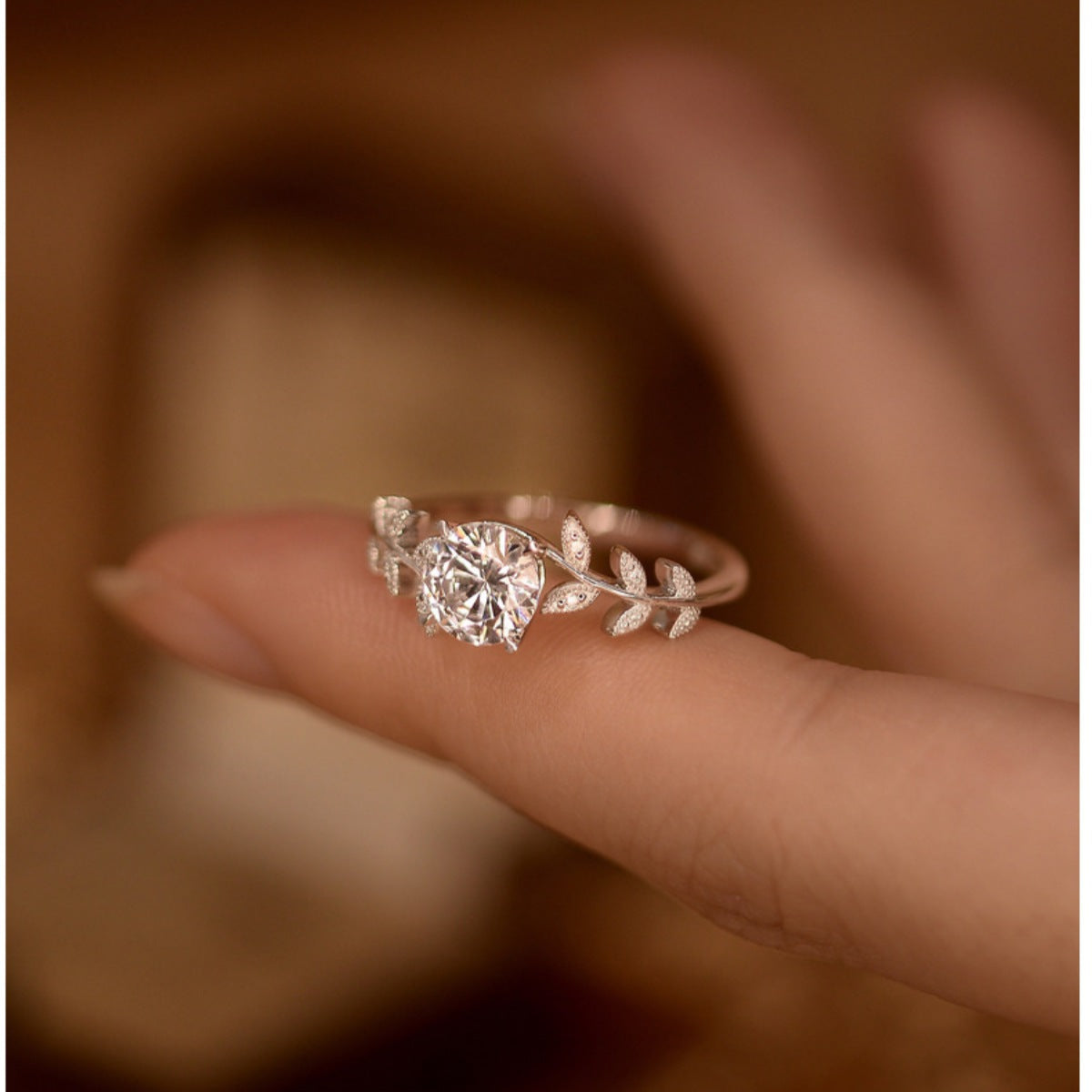 Round moissanite leaf ring with glittering center stone and curved branch band