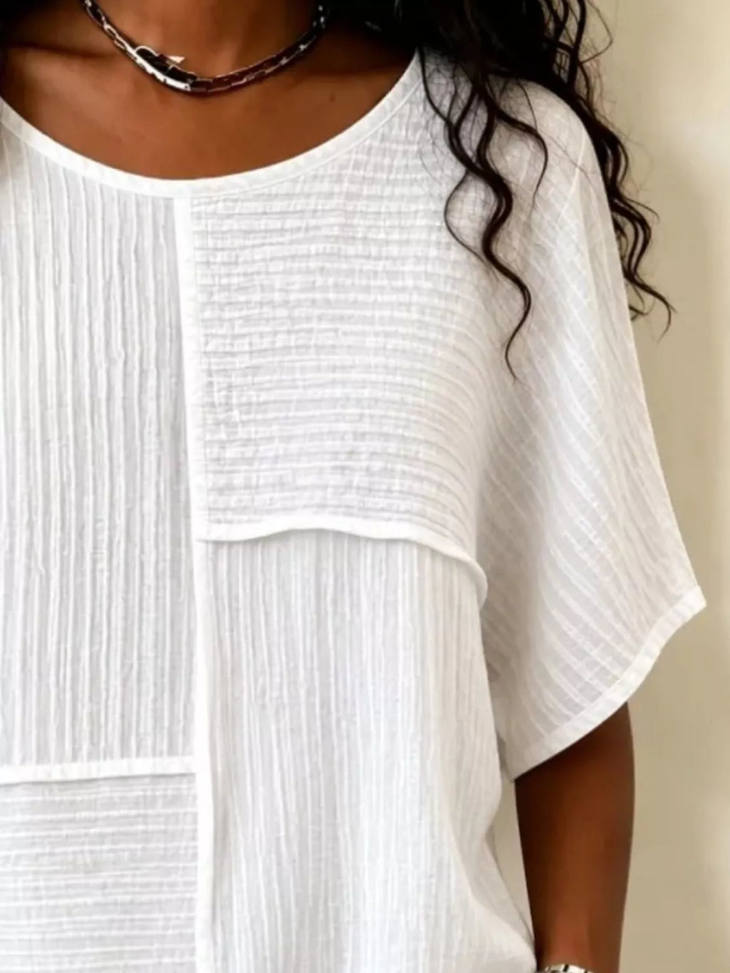 White textured round-neck half-sleeve blouse close-up of vertical seam panel