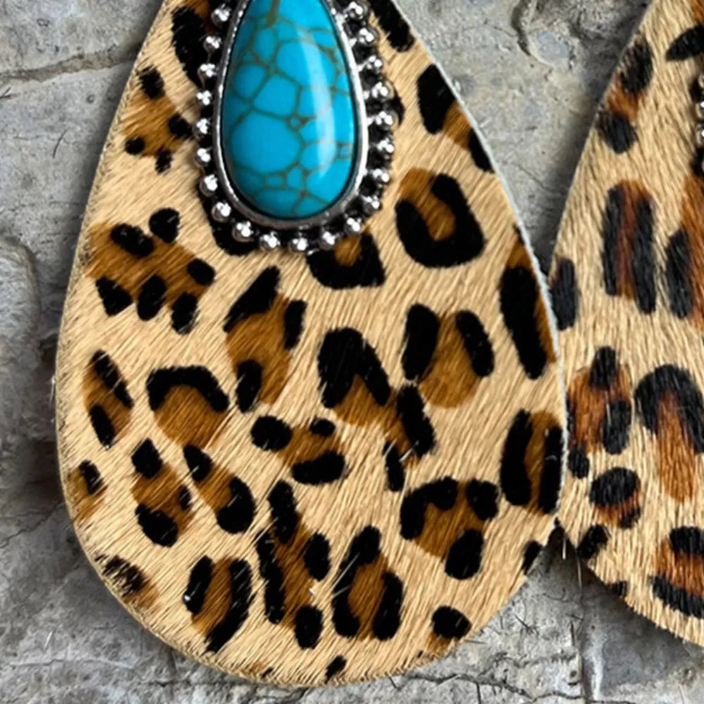Turquoise teardrop earrings with ornate silver border on leopard print dangle leather