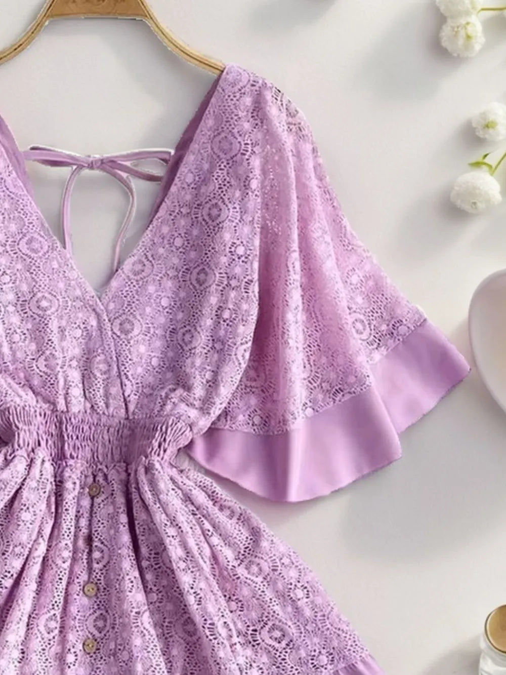 Lavender lace mini dress with tie-back straps and flared ruffle hem