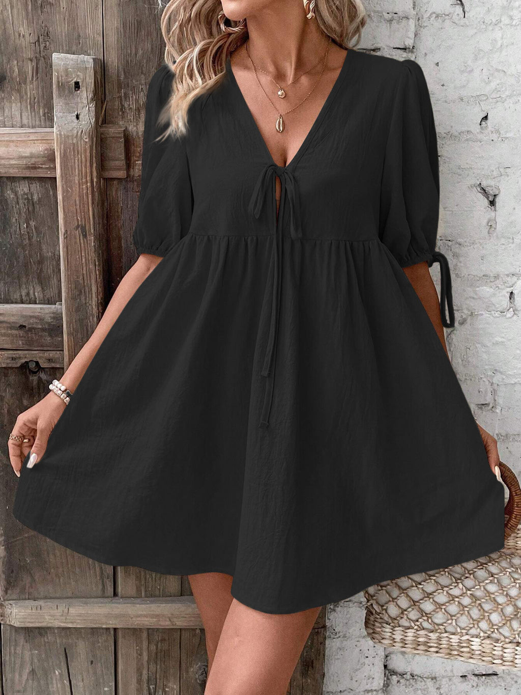 Black V-neck babydoll mini dress with center tie and puff sleeves