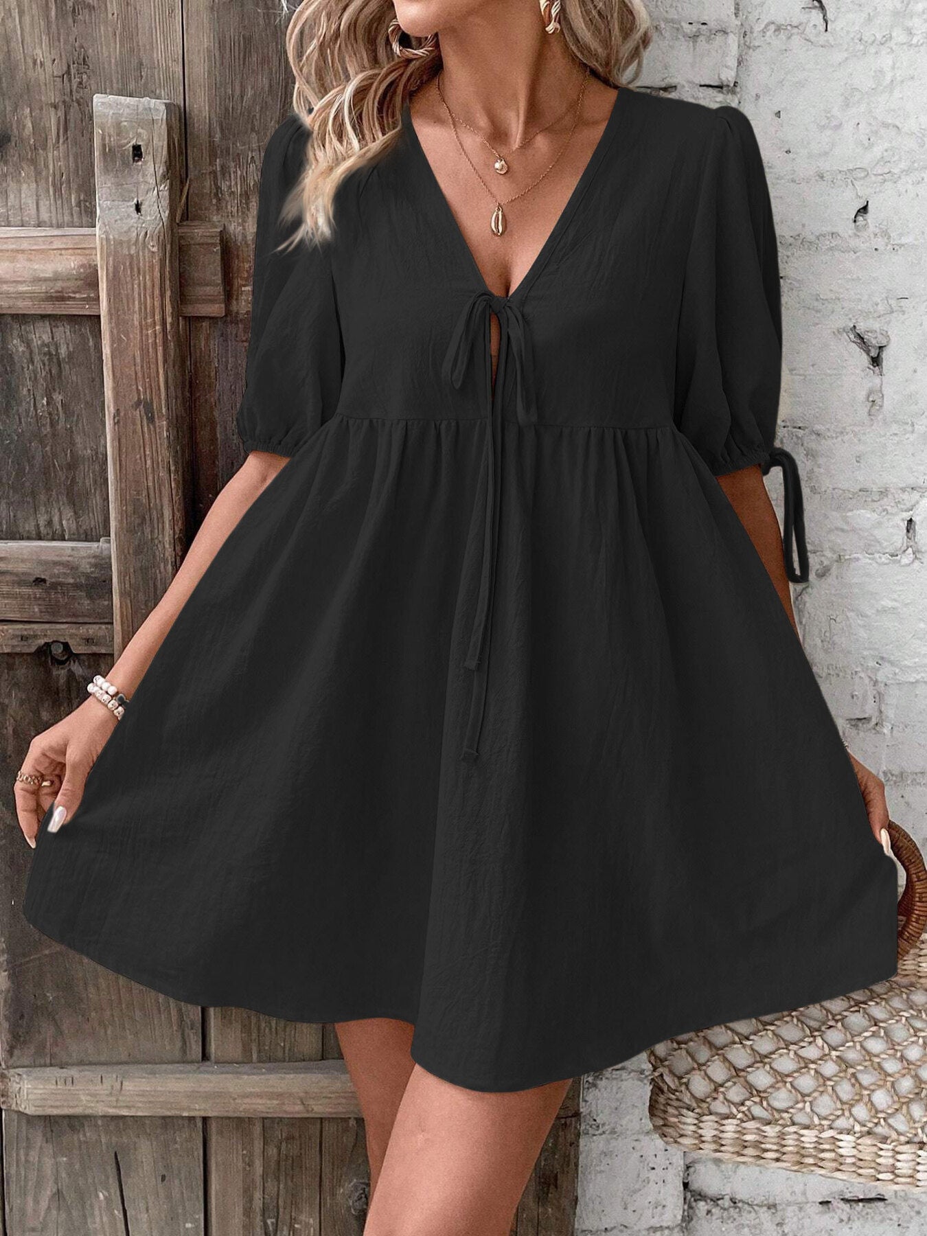Black V-neck babydoll mini dress with center tie and puff sleeves