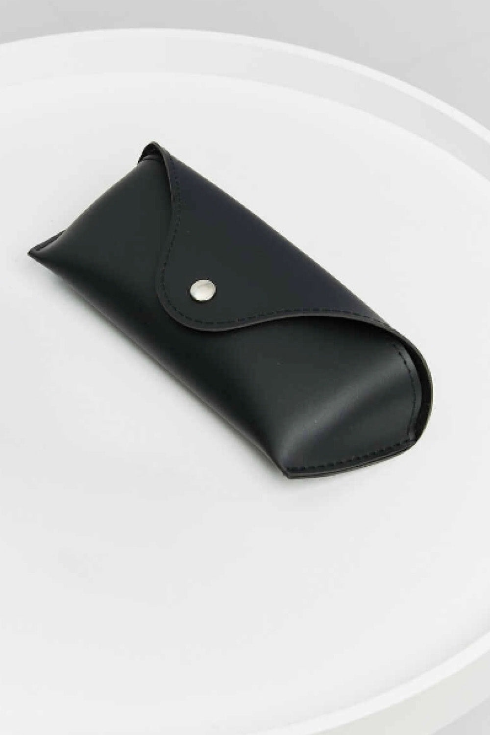Black eyeglass case with snap closure and stitched leatherette exterior