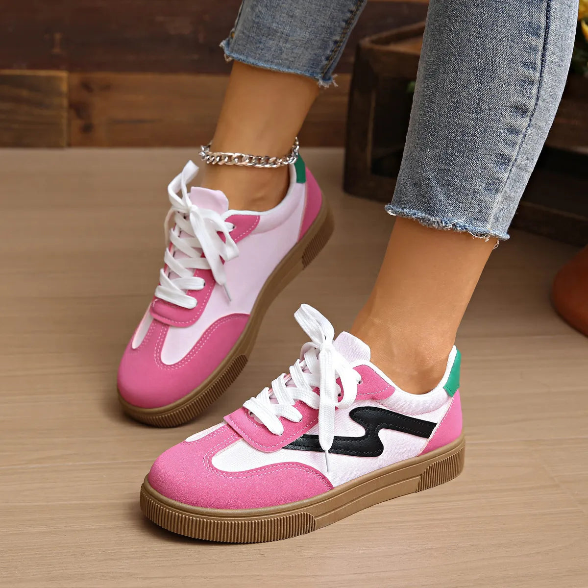 Pink lace-up sneakers with white laces and black side stripe detail