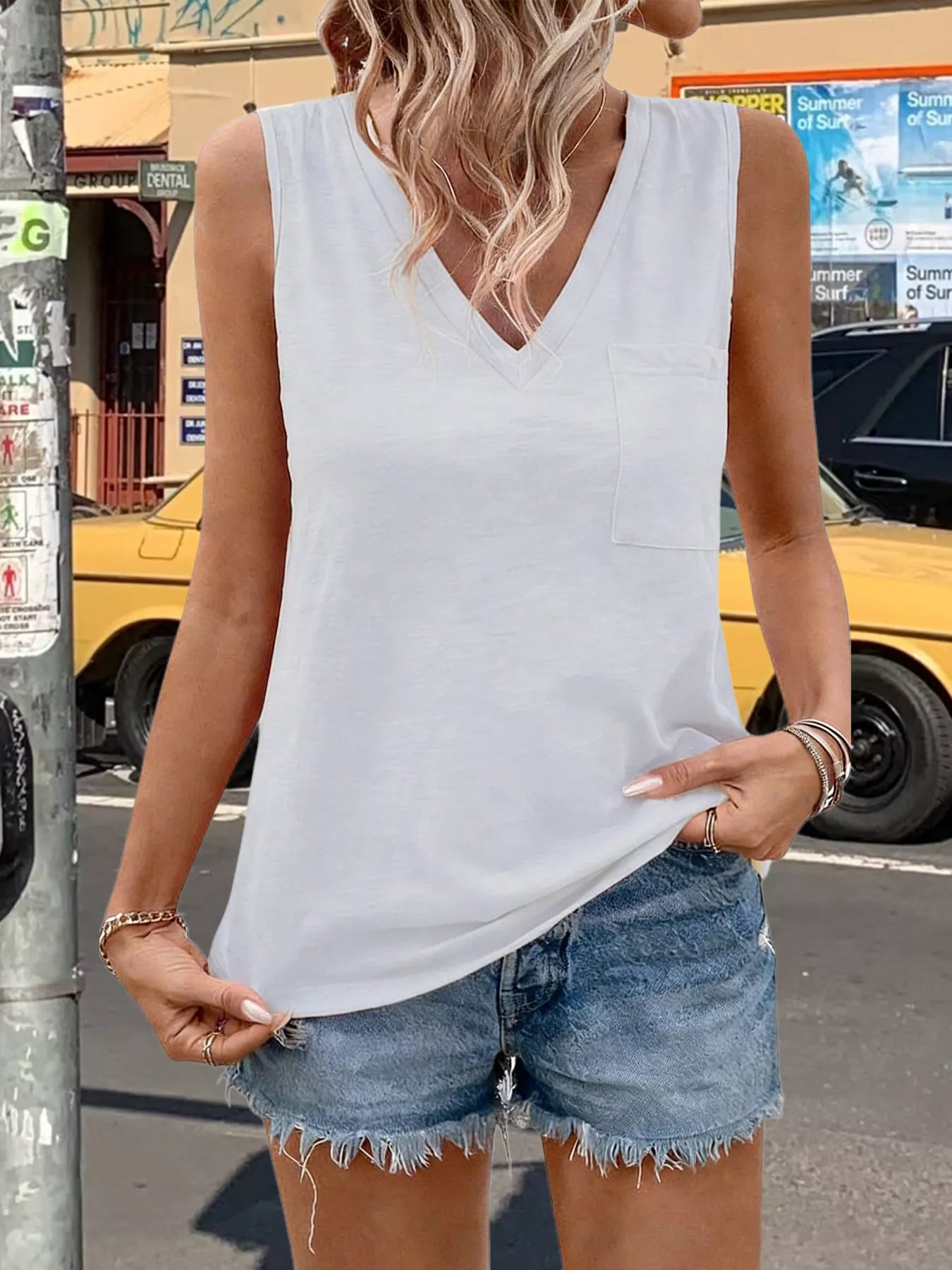 White sleeveless V-neck tank top with front chest pocket