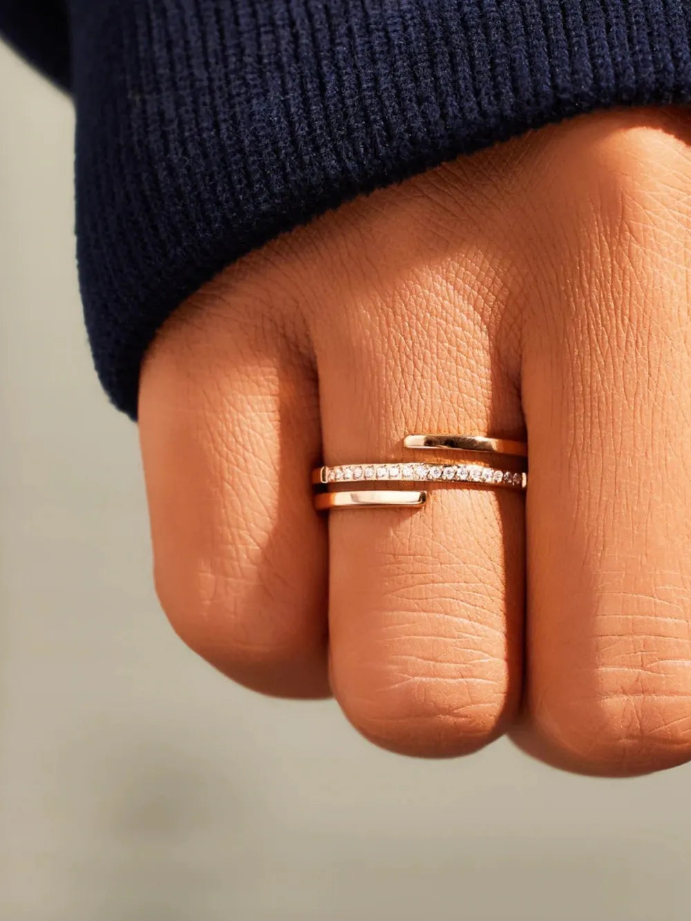 Gold-tone zircon inlay ring on finger with two slim bands and stone row