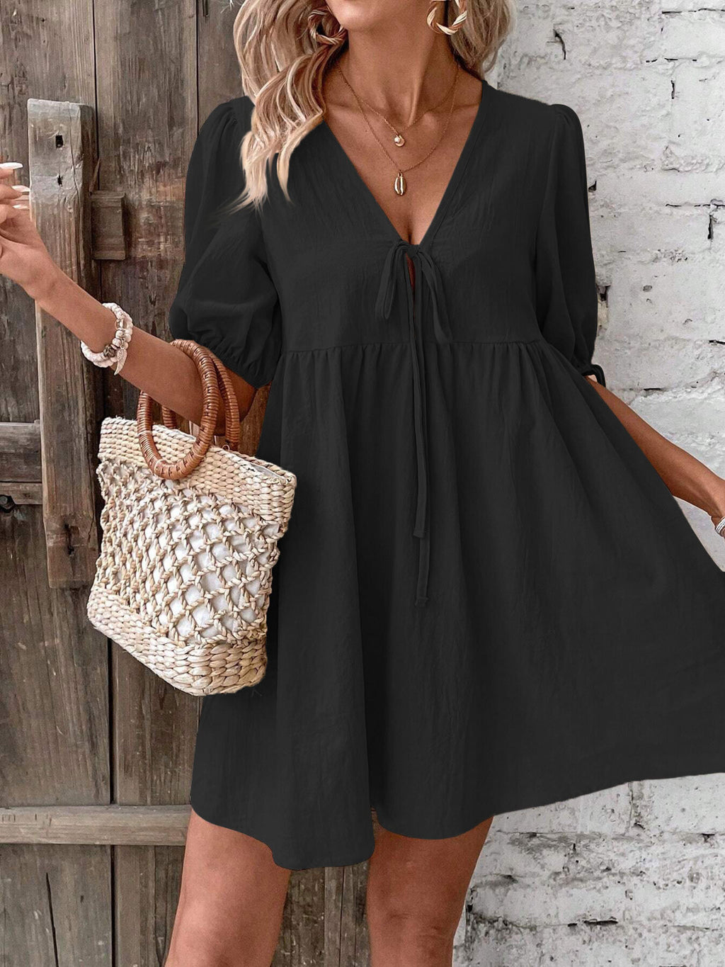 Black V-neck mini dress with ruched waist and tie front