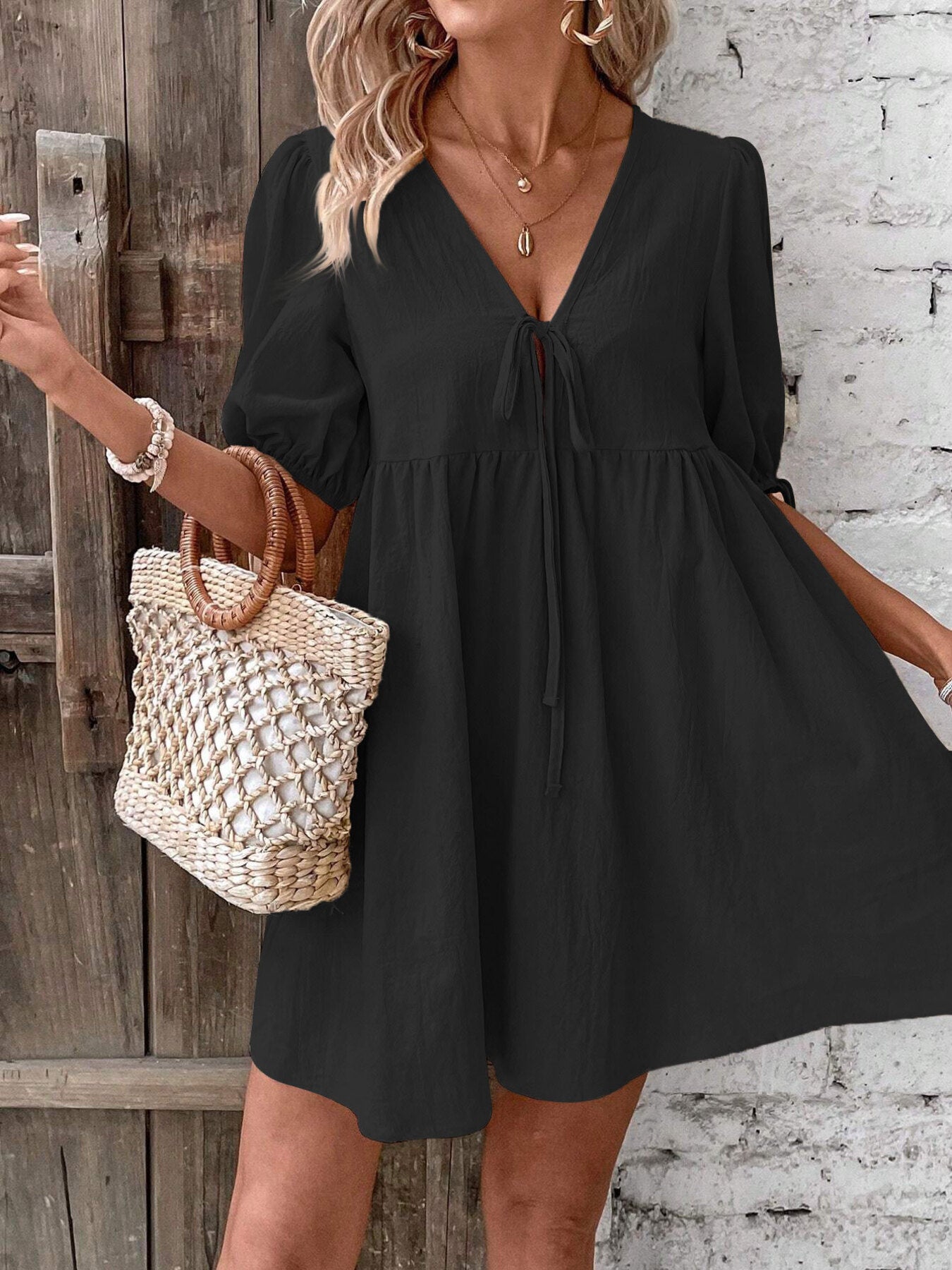 Black V-neck mini dress with ruched waist and tie front