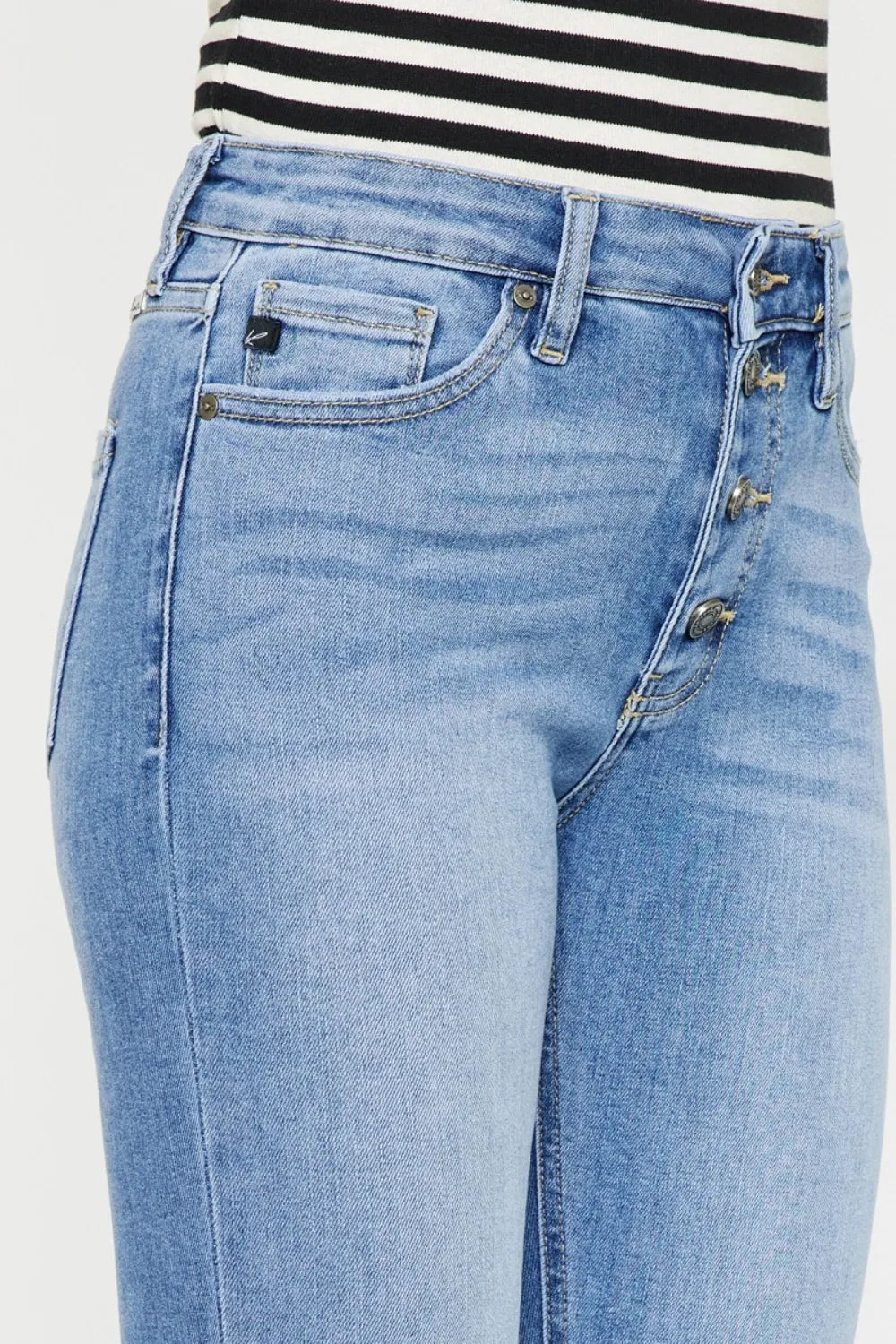 Light wash button-fly jeans close-up: front pockets, gold hardware, denim stitching