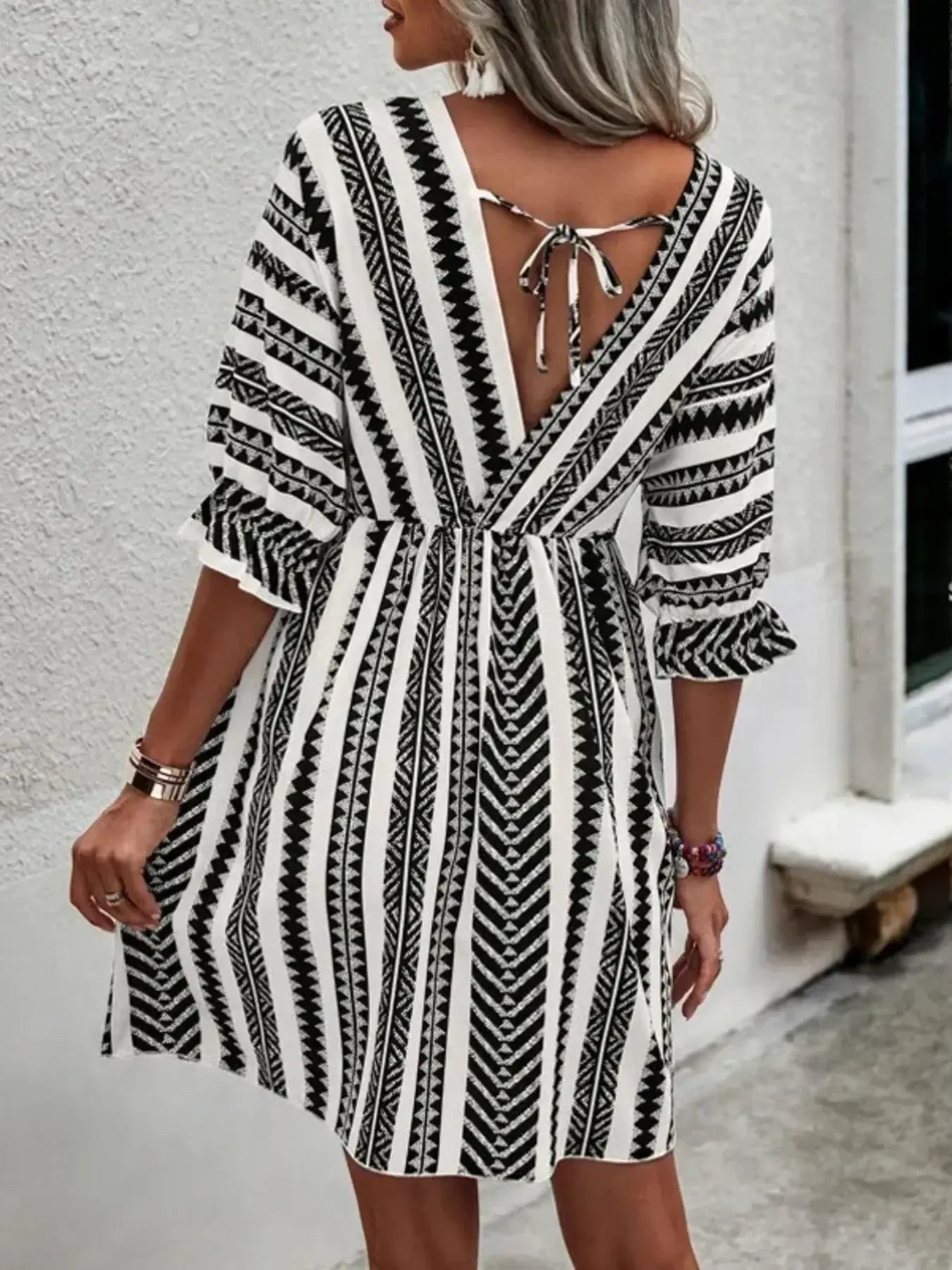 Black-and-white geometric mini dress with V-neck and open back tie strap detail
