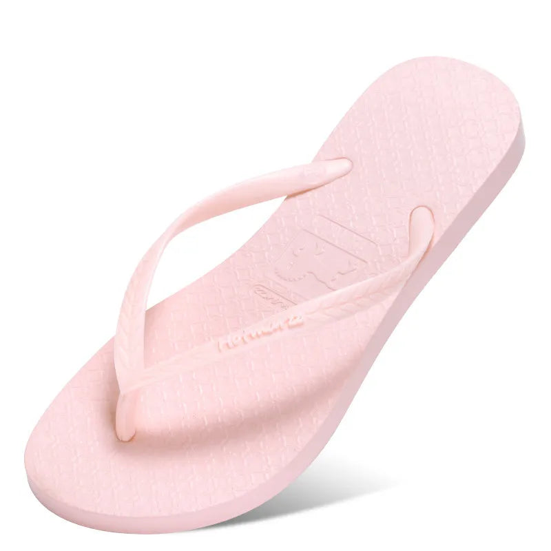 Pink toe-post flat sandals with textured footbed and slim thong strap