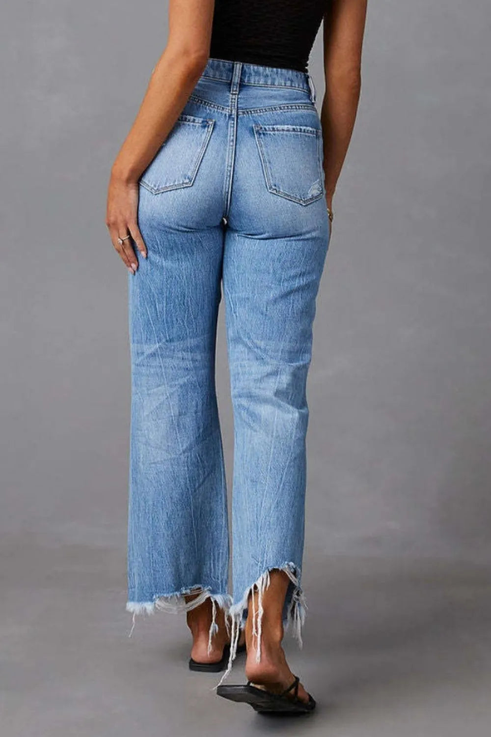 Light blue denim jeans with back pockets and frayed raw hem