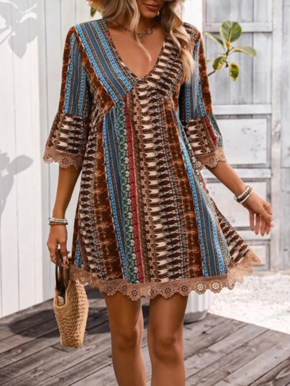 V-neck printed dress with 3/4 sleeves, lace hem, rust blue brown striped pattern