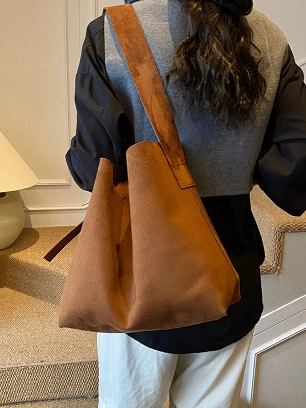 Brown tote bag with buckle strap and structured gusseted sides
