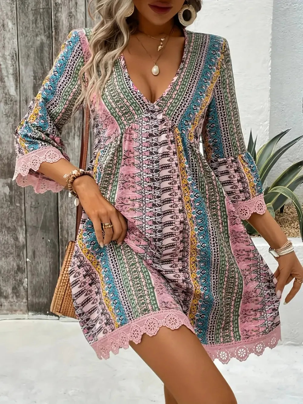 Blush pink V-neck mini dress with multicolor stripes, lace sleeves, and corset front