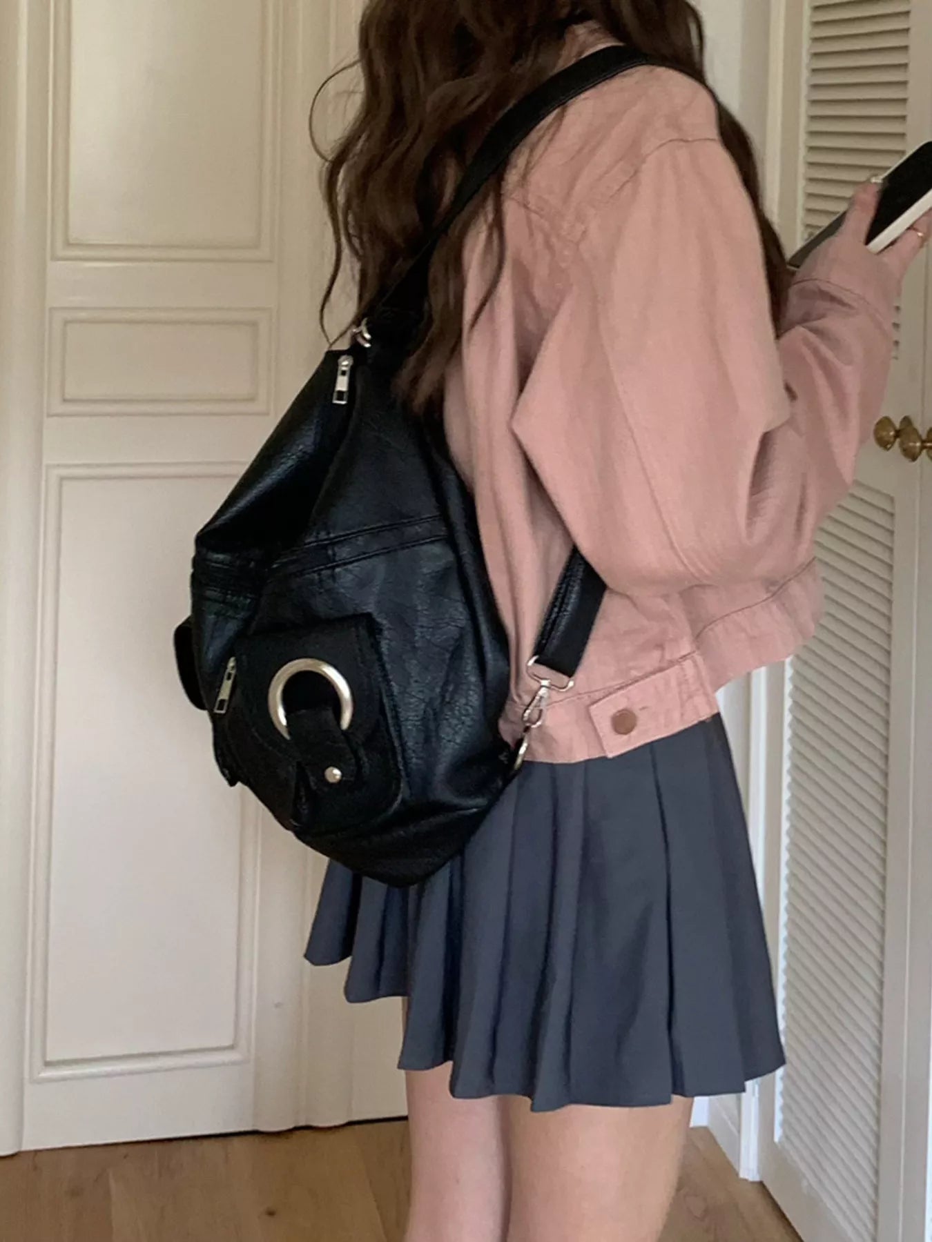 Convertible pocket handbag, black; side view with front ring accent and shoulder strap