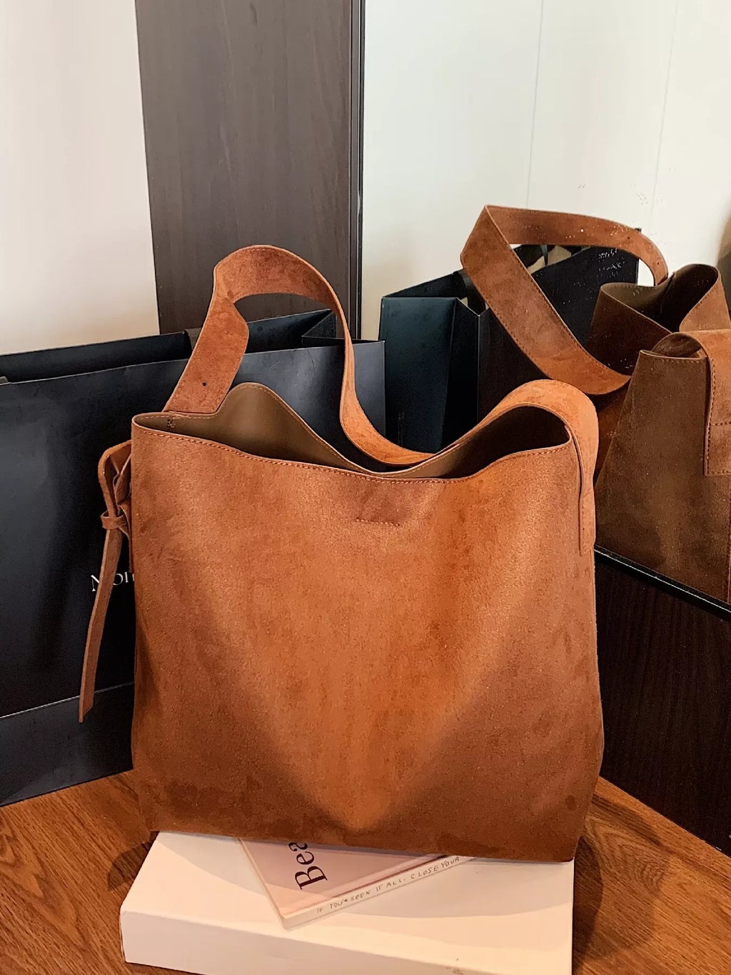 Cognac-brown suede tote bag with two strap handles and slouchy shape