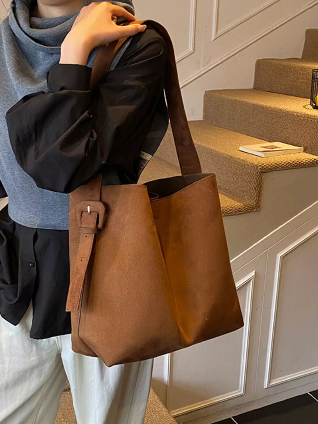 Brown tote bag with adjustable buckle strap, structured shape and wide opening