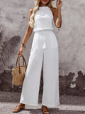 White sleeveless wide-leg jumpsuit, high neck, tassel drawstring waist
