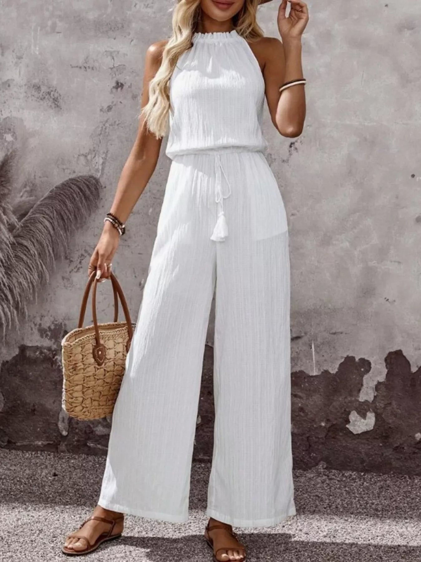 White sleeveless wide-leg jumpsuit, high neck, tassel drawstring waist