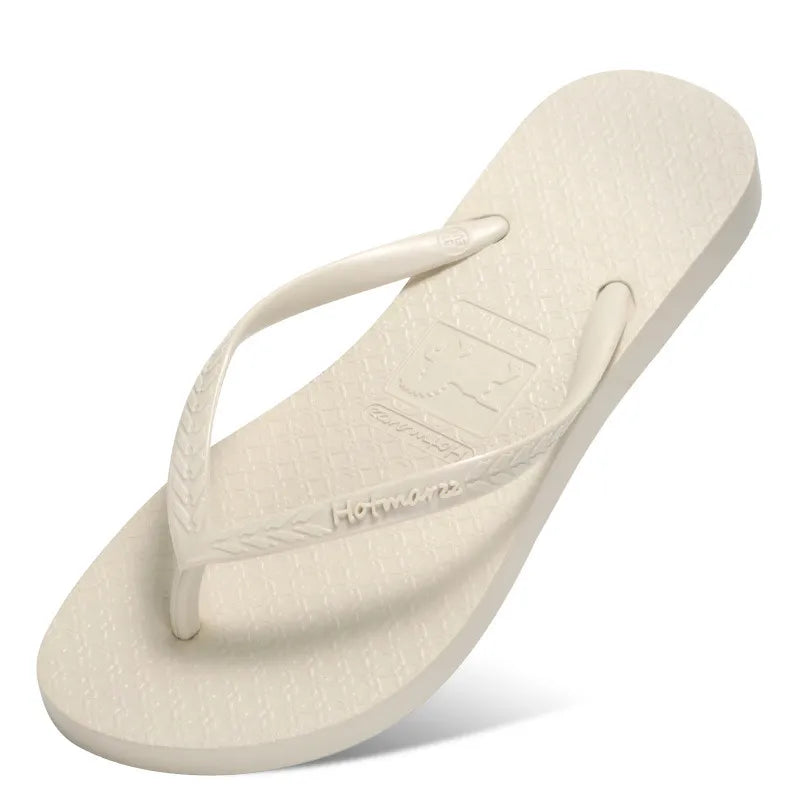 White toe-post flat sandals with textured footbed and matching thong strap
