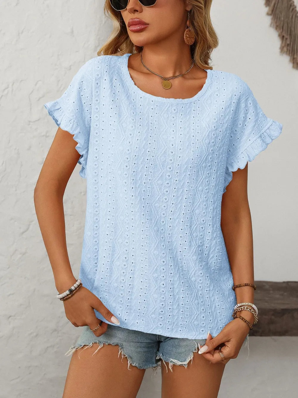Light blue eyelet round-neck short-sleeve top with flutter sleeves and textured stitch pattern
