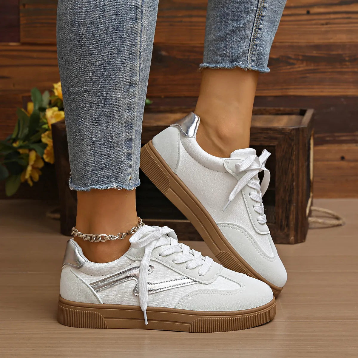 White lace-up sneakers with silver side panel and tan rubber sole