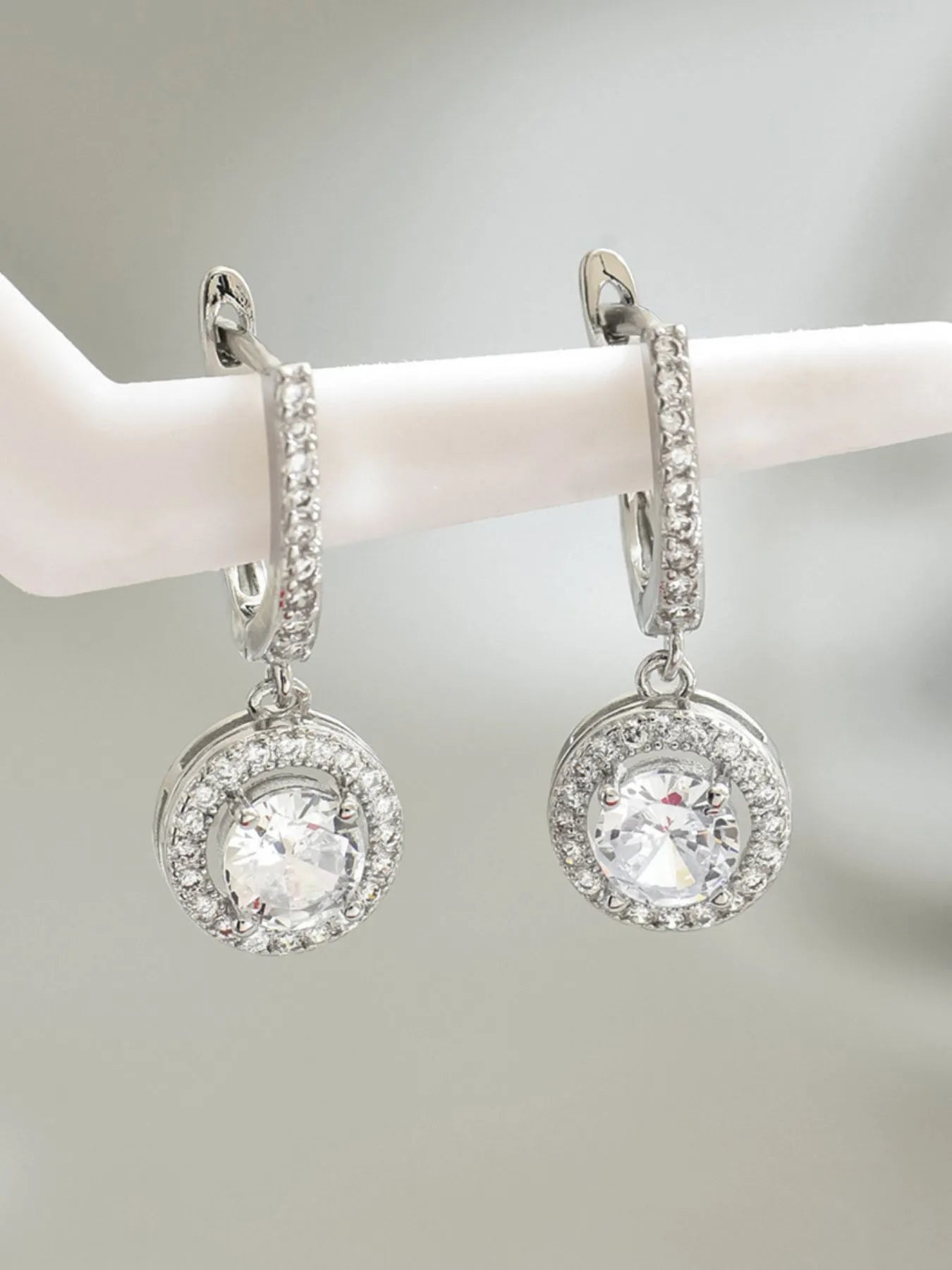 Pair of silver zircon drop earrings with round crystal halo and hanging hoop