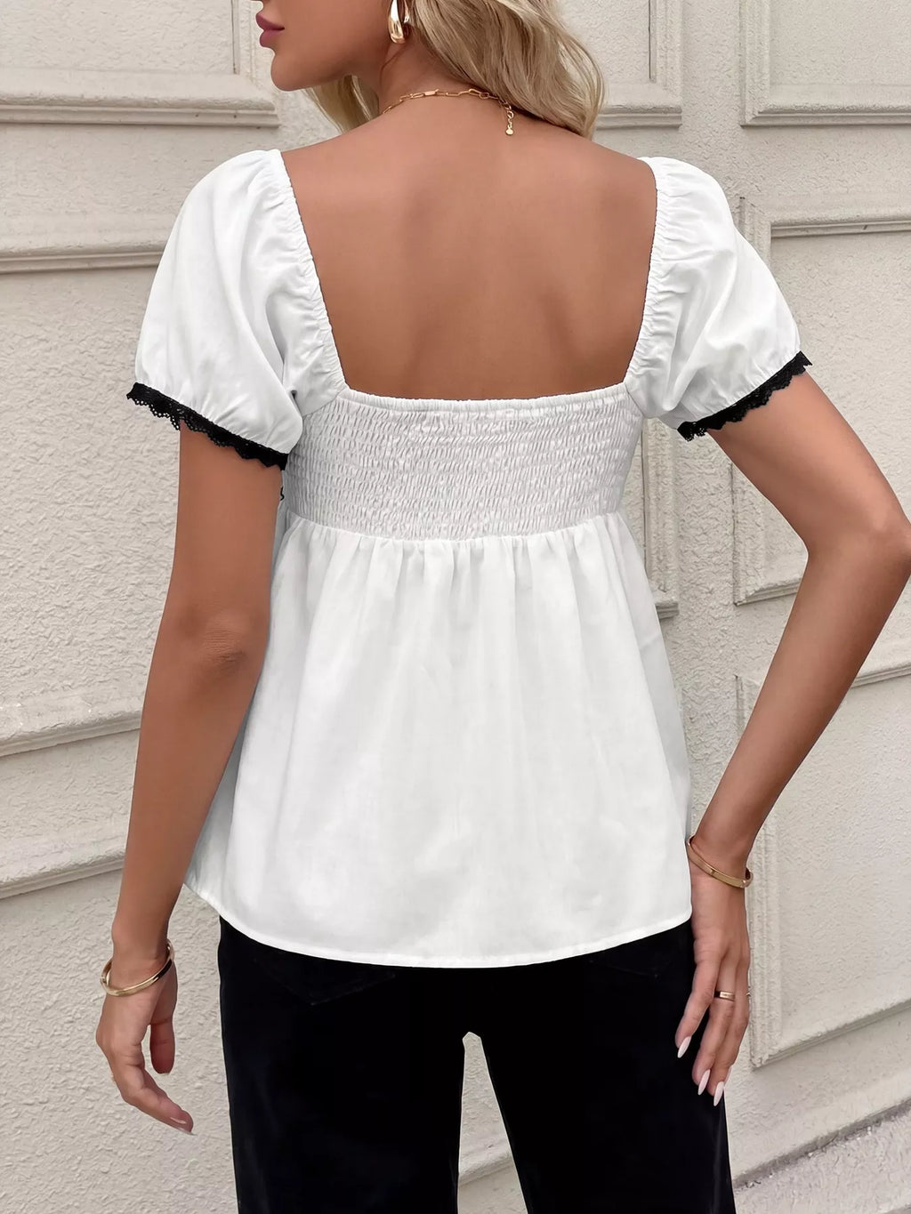 White short sleeve blouse back view with smocked waist and ruffled lace trim