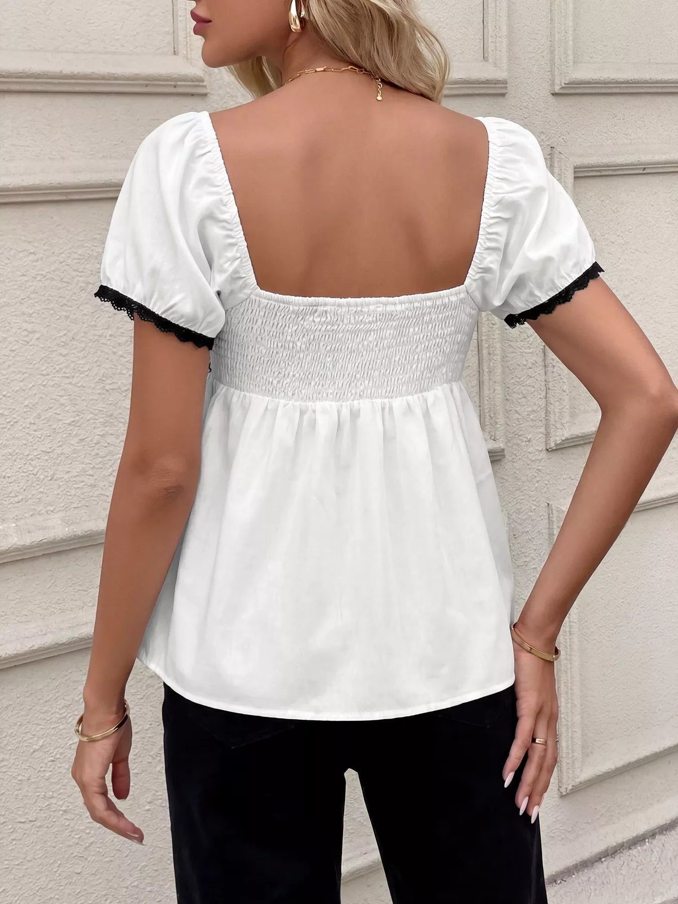 White short sleeve blouse back view with smocked waist and ruffled lace trim