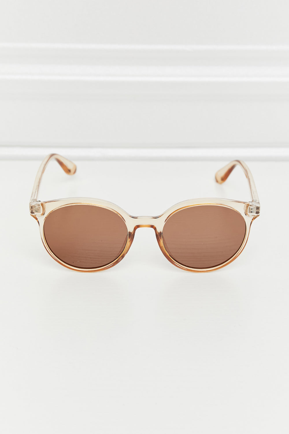 Tan round full-rim sunglasses with brown tinted lenses and slim temples