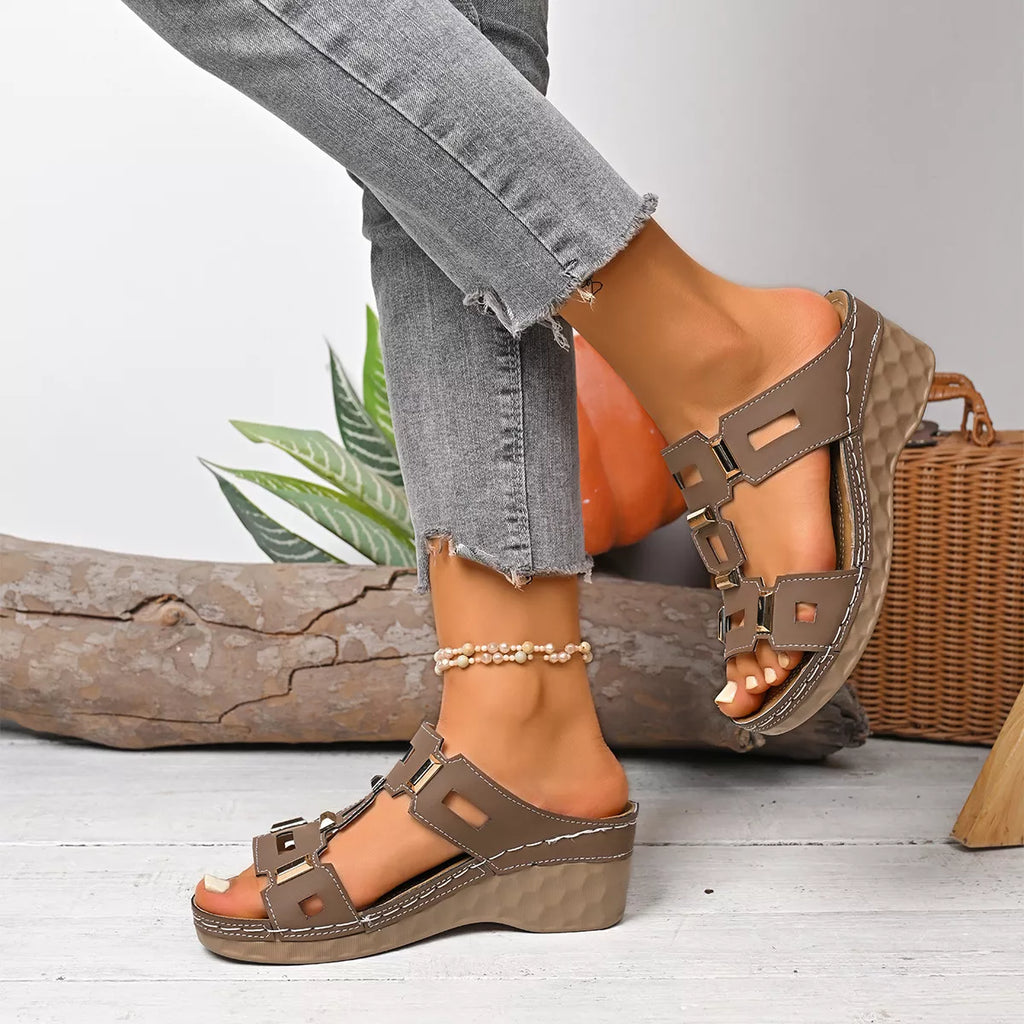 Open-toe wedge sandal in dark brown with crisscross buckle straps and textured wedge