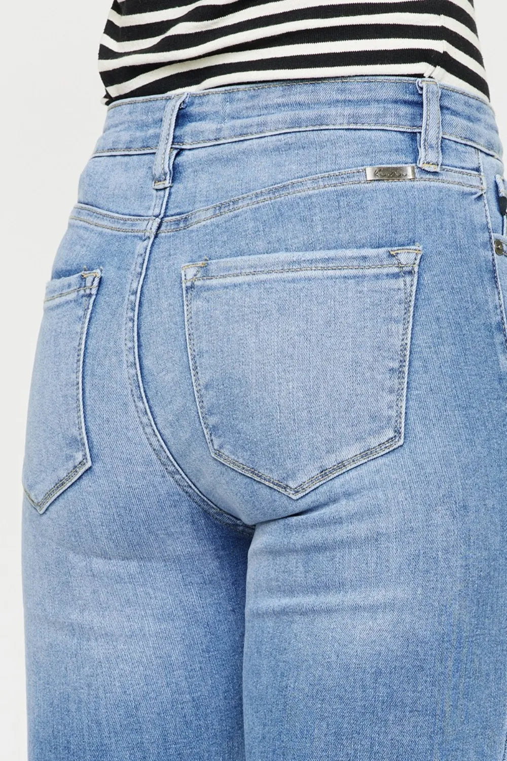 Light wash button-fly jeans close-up of back yoke and single back pocket