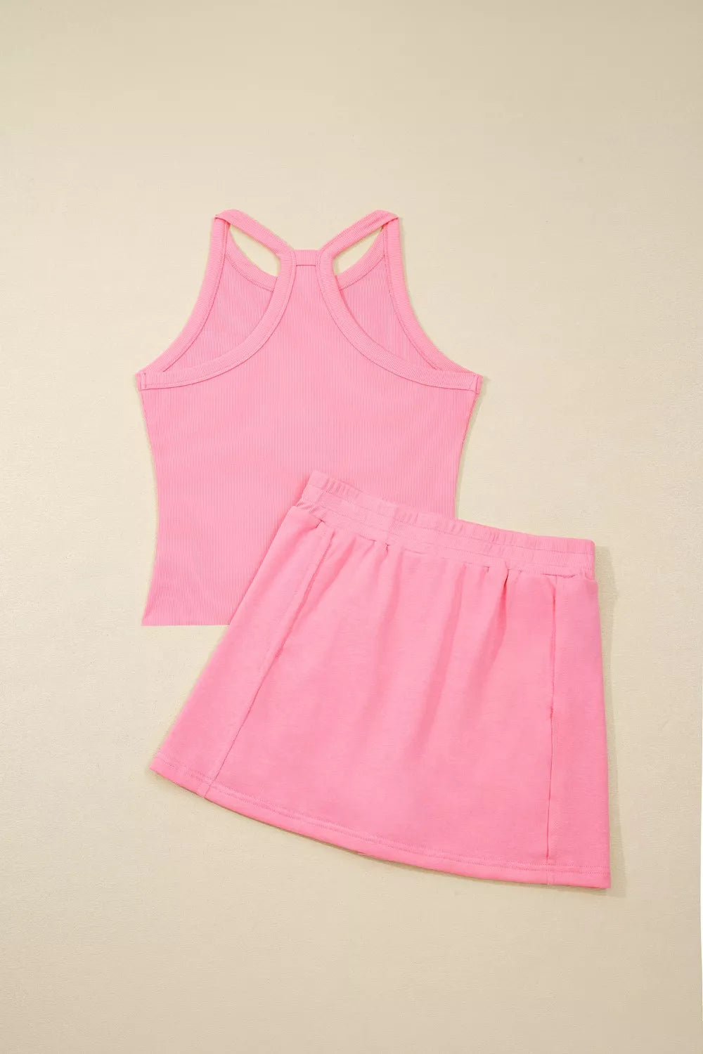 Dusty pink sleeveless cropped top with crisscross back straps and skort, matching set