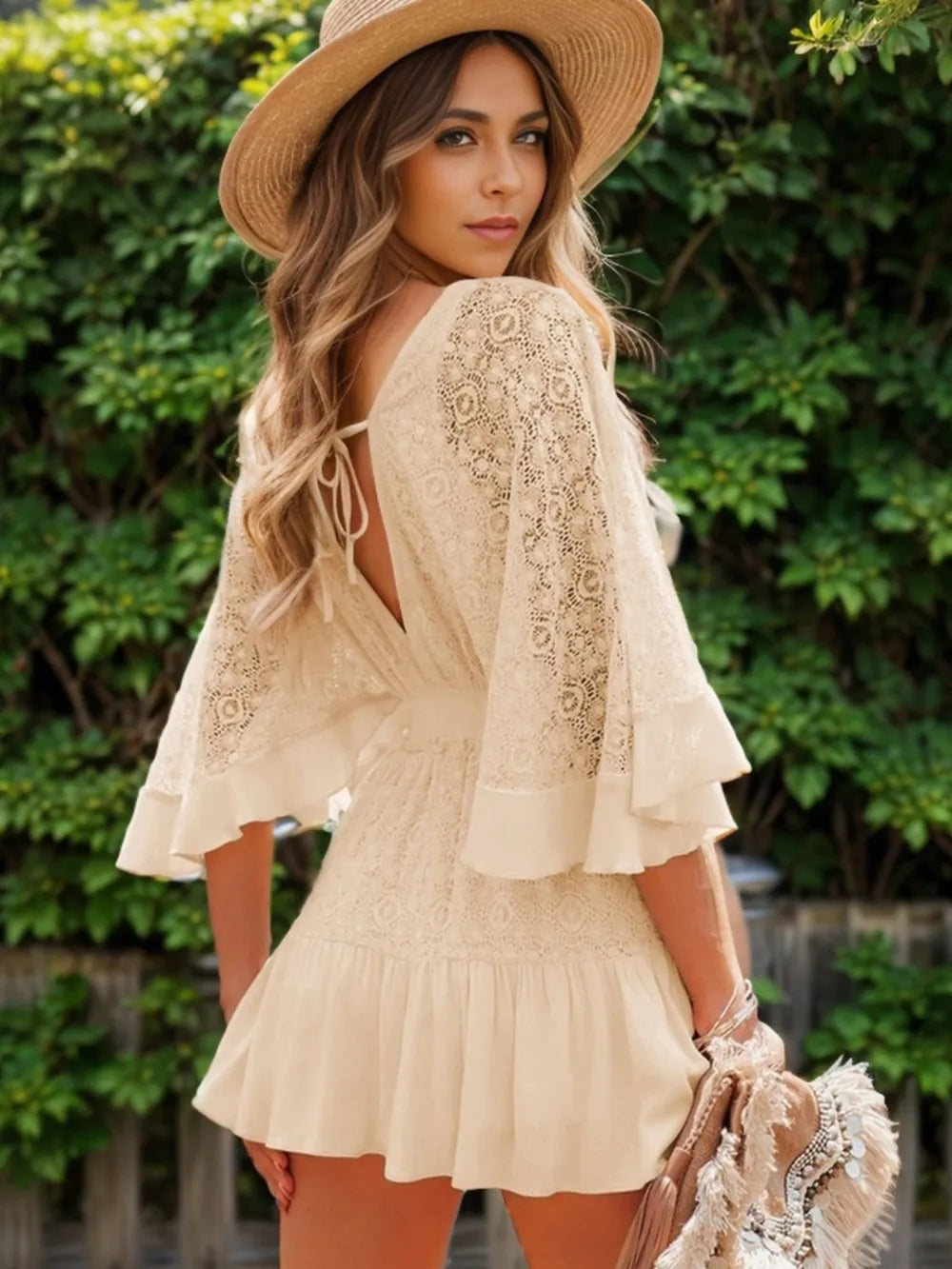 Cream lace mini dress with ruffle hem, tie-back, and open back detail