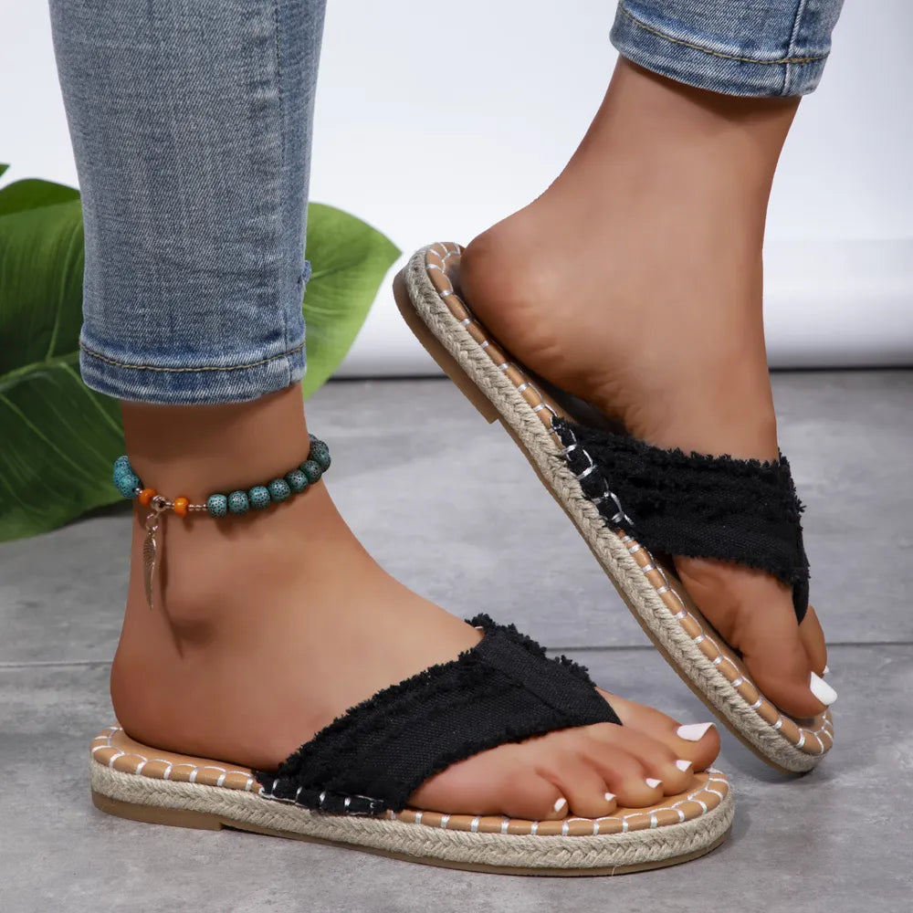Black toe-post flat sandals with frayed cross strap and tan jute-look sole