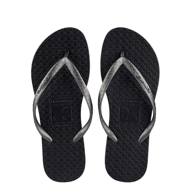 Black toe-post flat sandals with textured thong straps and V-shaped sole