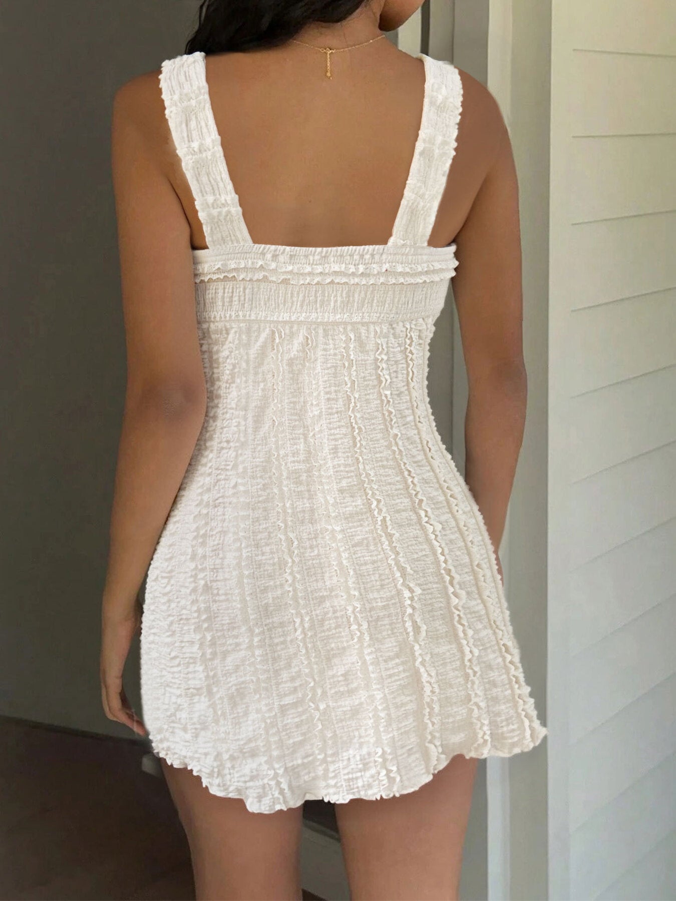 Cream textured mini dress with square back, wide straps, and smocked bodice